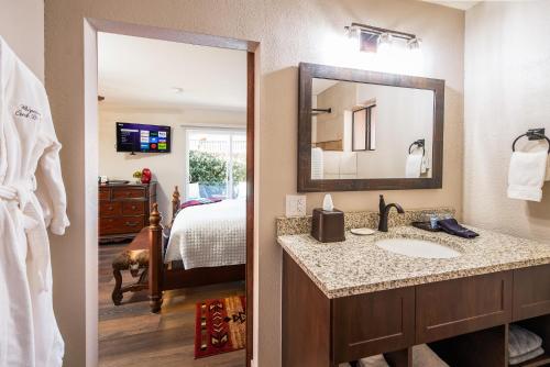 a bathroom with a sink and a bedroom with a bed at Whispering Creek Bed & Breakfast in Sedona