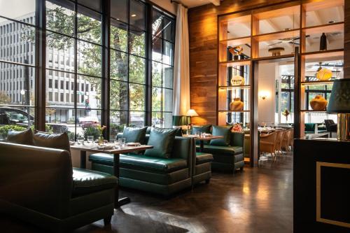 a restaurant with green furniture and large windows at Eurostars St Gregory Dupont Circle Georgetown in Washington