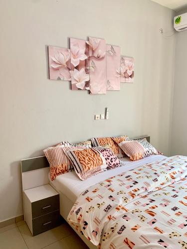 um quarto com uma cama com flores na parede em Résidence Magnificat em Kribi