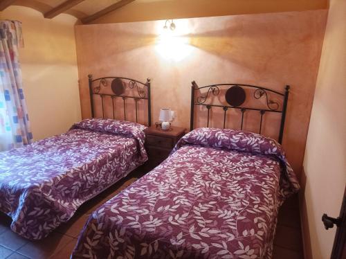 two beds sitting next to each other in a room at casas rurales ivan el penas 3 in Letur