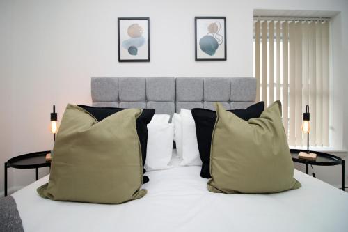 ein Schlafzimmer mit einem weißen Bett mit schwarzen und weißen Kissen in der Unterkunft No2 Under the Clock by SSW - Cardiff City Centre in Cardiff