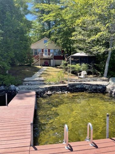 a bridge over a river with a house in the background at MOOSEY ON INN LIMIT 8 cottage in Hillside
