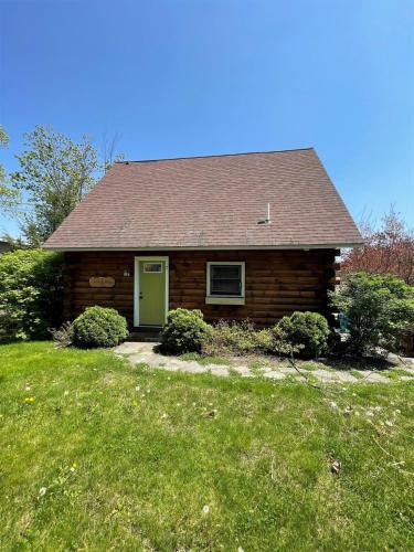 a small house with a green door in a yard at CAMP MARCY LIMIT 8 cottage in Standish