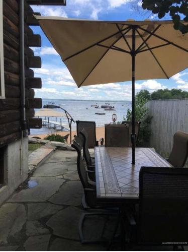 a table and chairs with an umbrella on the beach at CAMP MARCY LIMIT 8 cottage in Standish