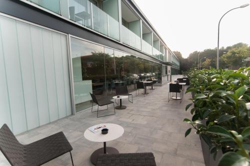 a patio with tables and chairs and a building at Hotel Sorli Emocions in Vilassar de Dalt