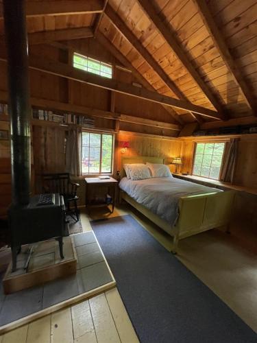 a bedroom with a bed in a room with wooden ceilings at MACKINNEY CAMP - LIMIT 8 cottage in Standish