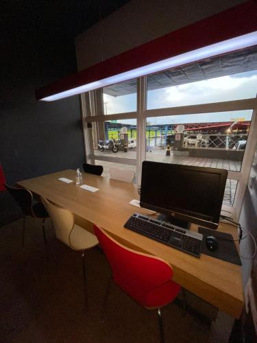 a desk with a computer on it with a window at Hotel Oeste Plaza in Andradina