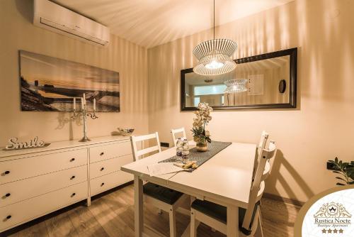 una sala da pranzo con tavolo, sedie e comò di Rustica Nocte Boutique Apartments a Požega
