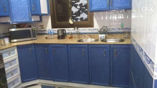 a blue kitchen with a sink and a microwave at شقه مفروش in Cairo