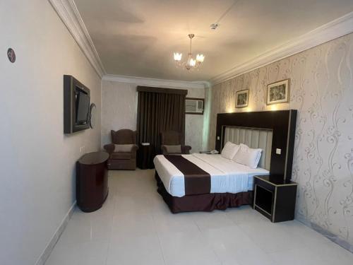 une chambre d'hôtel avec un lit et une chaise dans l'établissement طارق الطائف, à Taif
