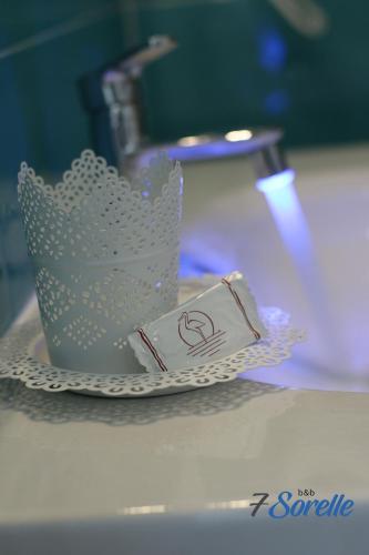 a white cup on a plate on a table at "7 SORELLE B&B" camere in pieno centro città con bagno privato, FREE HIGH SPEED WI-FI, NETFLIX in Cosenza