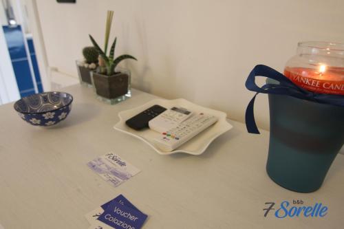 a table with a drink and a remote control on it at "7 SORELLE B&B" camere in pieno centro città con bagno privato, FREE HIGH SPEED WI-FI, NETFLIX in Cosenza