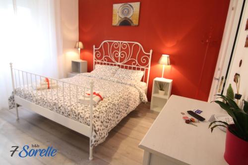 a bedroom with a white bed and a red wall at "7 SORELLE B&B" camere in pieno centro città con bagno privato, FREE HIGH SPEED WI-FI, NETFLIX in Cosenza