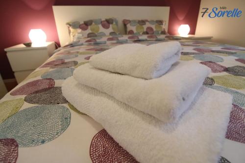 a bed with white towels on top of it at "7 SORELLE B&B" camere in pieno centro città con bagno privato, FREE HIGH SPEED WI-FI, NETFLIX in Cosenza