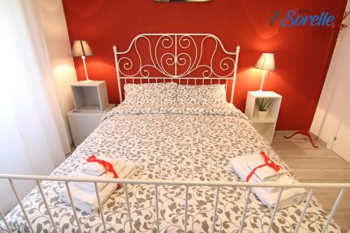 a bedroom with a bed with a metal bed frame at "7 SORELLE B&B" camere in pieno centro città con bagno privato, FREE HIGH SPEED WI-FI, NETFLIX in Cosenza