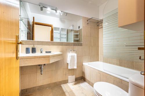 a bathroom with a sink and a tub and a toilet at Machico City Apt in Machico