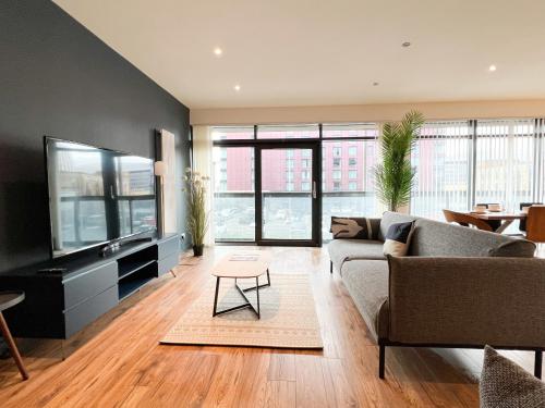 a living room with a couch and a flat screen tv at Lovely two bed apartment in Finnieston in Glasgow