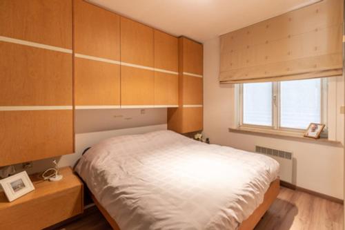 a bedroom with a bed and wooden cabinets at Apartment Casino in Nieuwpoort
