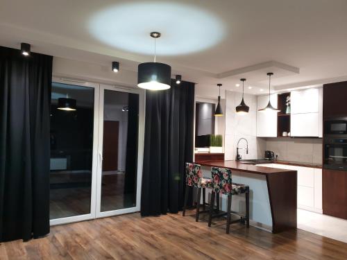 a kitchen with black curtains and a counter with chairs at No 59 Apartament in Nowy Targ