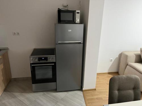 uma cozinha com um micro-ondas em cima de um frigorífico em HG apartment em Jelah