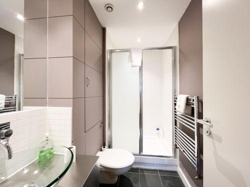 a bathroom with a toilet and a glass sink at Lovely two bed apartment in Finnieston in Glasgow