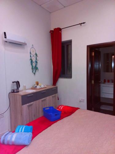 a bedroom with a bed and a sink and a red curtain at Cittadella b&b in Victoria