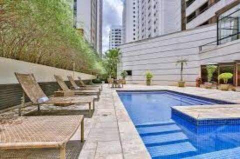 - une piscine avec des chaises longues à côté d'un bâtiment dans l'établissement Flat com sacada e piscina, à São Paulo