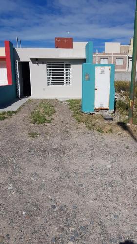 un edificio blanco con una nevera delante en Depto. Playa Unión en Playa Unión