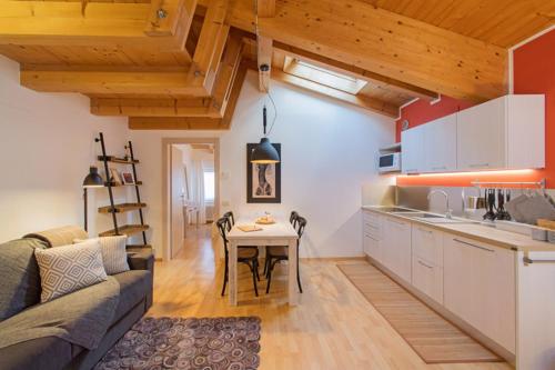 a kitchen and a living room with a couch and a table at La Casa di Trento in Trento