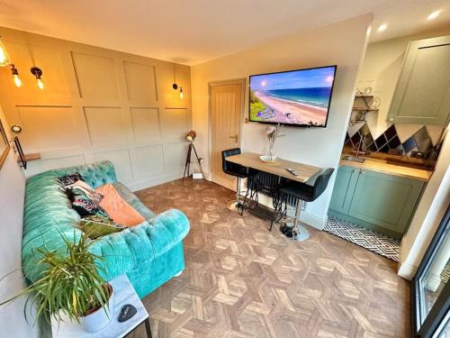 sala de estar con sofá azul y escritorio en Fortescue Lodge en Bournemouth