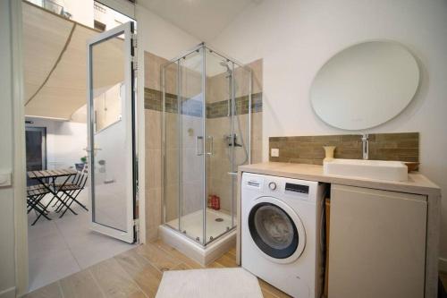 a bathroom with a washing machine and a shower at Appartement climatisé grande terrasse 2 chambres in Marseille