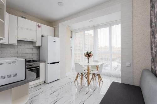 a kitchen with white appliances and a table with chairs at 091 квартира ЖК Софія Резиденс, 5 поверх in Vyshneve
