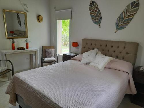 Un dormitorio con una cama grande y una ventana en Los Pinos - Costa del Este - Casa 6 personas en Costa del Este