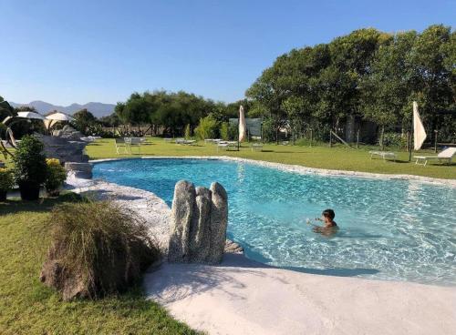 a person in a swimming pool in a park at Agriturismo Santa Lucia in Tratalias