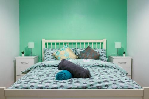 1 dormitorio con 1 cama con pared azul en Comfy 3 bedroom cottage super fast wifi, paid parking en Reading