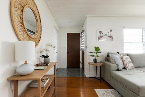 uma sala de estar com um sofá e um espelho em Palm House~Heated Pool~8 min to Beach em Largo