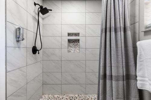 uma casa de banho com chuveiro e cortina de chuveiro em Palm House~Heated Pool~8 min to Beach em Largo