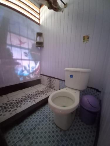 een badkamer met een wit toilet in een kamer bij Hostal tachiwa in Puerto Nariño