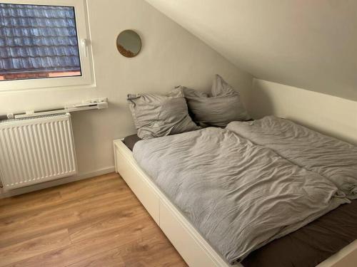 Cama pequeña en habitación con ventana en Dein Haus am Rhein, en Coblenza