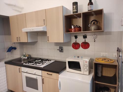 a small kitchen with a stove and a microwave at Cinecasa di Andrea e Cristina in Turin