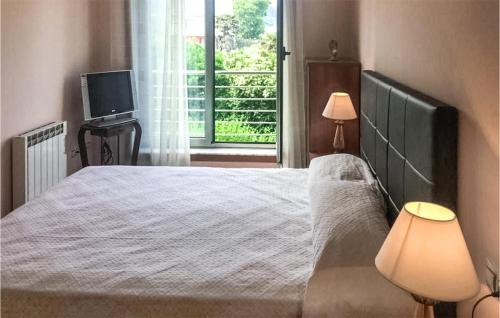 um quarto com uma cama, uma televisão e uma janela em Beautiful Apartment In O Porto De Espasante With Wifi em Porto de Espasante