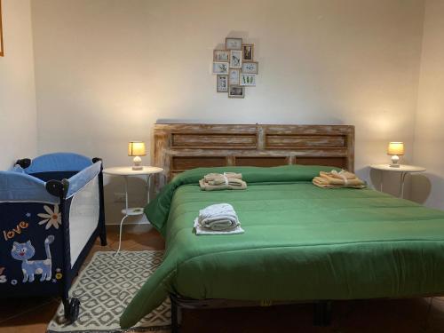 巴勒摩的住宿－Da Rosina，一间卧室配有一张带两张桌子的绿色床
