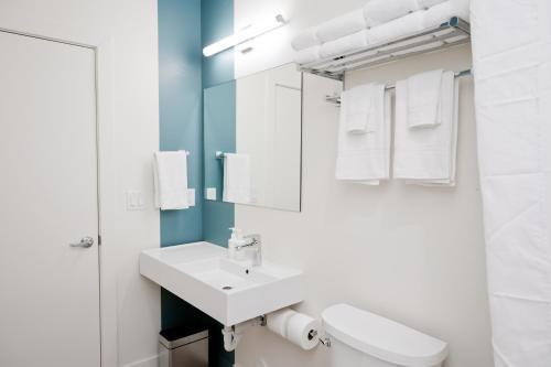 a white bathroom with a sink and a mirror at Skyview Hotel in Torrey