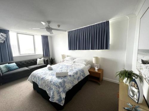 a bedroom with a bed with a laptop on it at Beach Front Ocean View 3 Bedroom Apartment in Maroochydore in Maroochydore