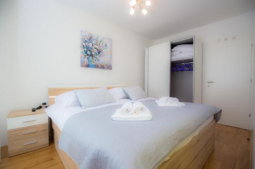 ein Schlafzimmer mit einem großen weißen Bett mit zwei Handtüchern darauf in der Unterkunft Vanilla apartment in Šibenik