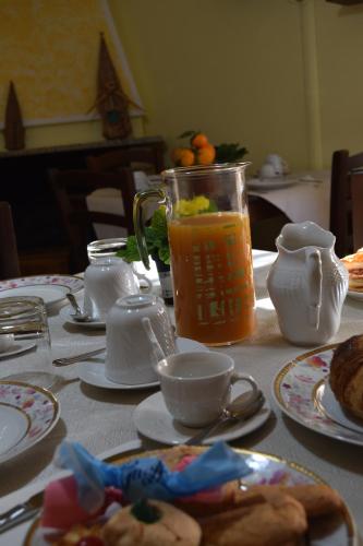 a table with plates of food and a pitcher of juice at Su Fassoi Cabras in Càbras