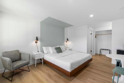 a bedroom with a bed and a chair and a table at Cashmere Inn in Cashmere
