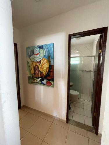 uma casa de banho com um quadro na parede e um chuveiro em Casa à beira do lago em Divinópolis
