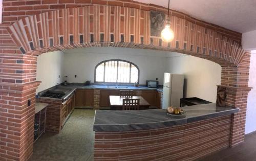 una cocina con un arco de ladrillo en una habitación en Hostal Casa Flor de Limón en Tepoztlán