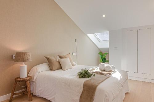 a bedroom with a white bed with a window at Riazor Deluxe Penthouse in A Coruña